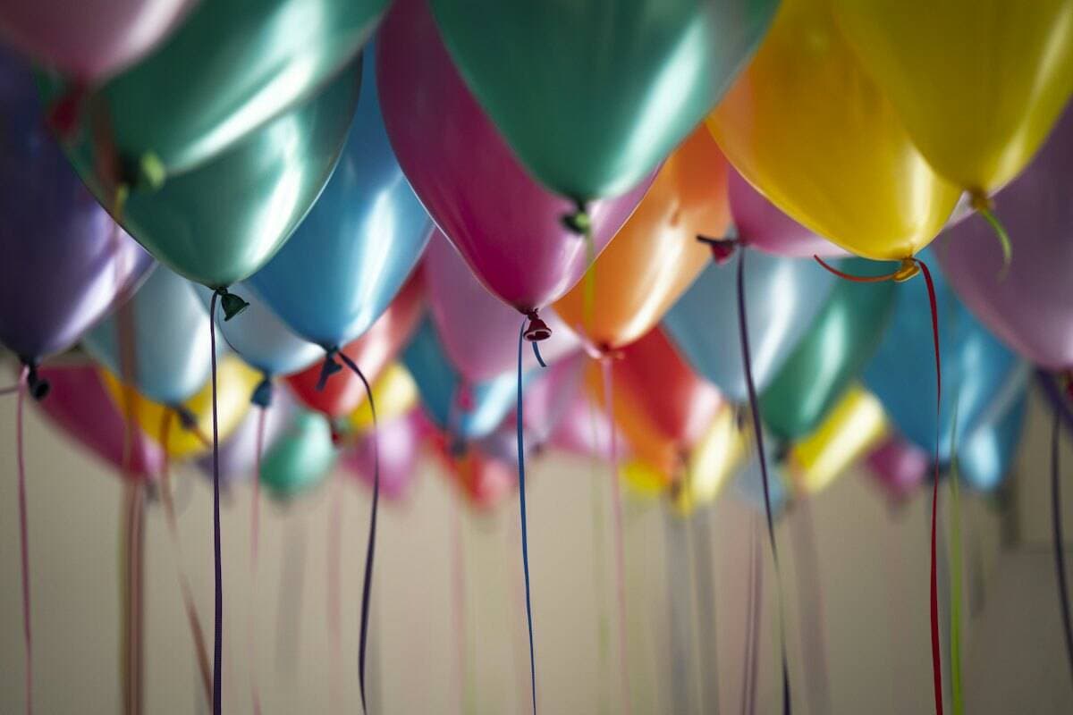 A birthday party set up with balloons and a cake table